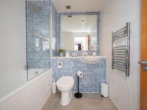 A modern bathroom with a glass shower enclosure, a white sink, and a toilet.