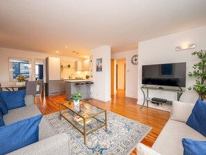 A modern living room with a sofa, coffee table, and TV.