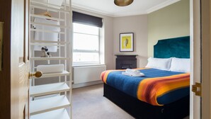 A bedroom with a bed, a wardrobe, a radiator, a window, and a framed picture on the wall. - Cool Covent Garden 1BR - Netflix & Nespresso (London)