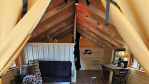 Une chambre mansardée chaleureuse, avec un lit, une petite table et une chaise.