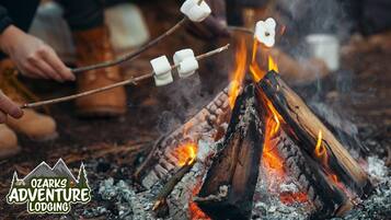 Een kampvuur met marshmallows die geroosterd worden.