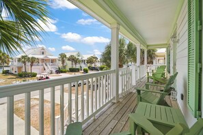 A covered porch with green chairs, a view of a residential street, and a clear sky. - Spacious Surfside Beach Home Minutes from the Ocean. Pet-Friendly! (Murrells Inlet)