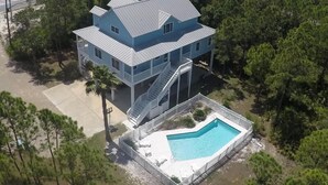 Una casa de dos pisos con un balcón grande y una piscina.