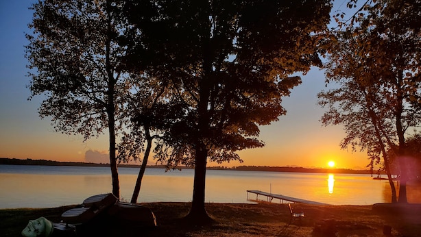 A lakeside view with trees and a dock. - Presque Isle Resort cottage #2 of 2 (3) (Alpena)