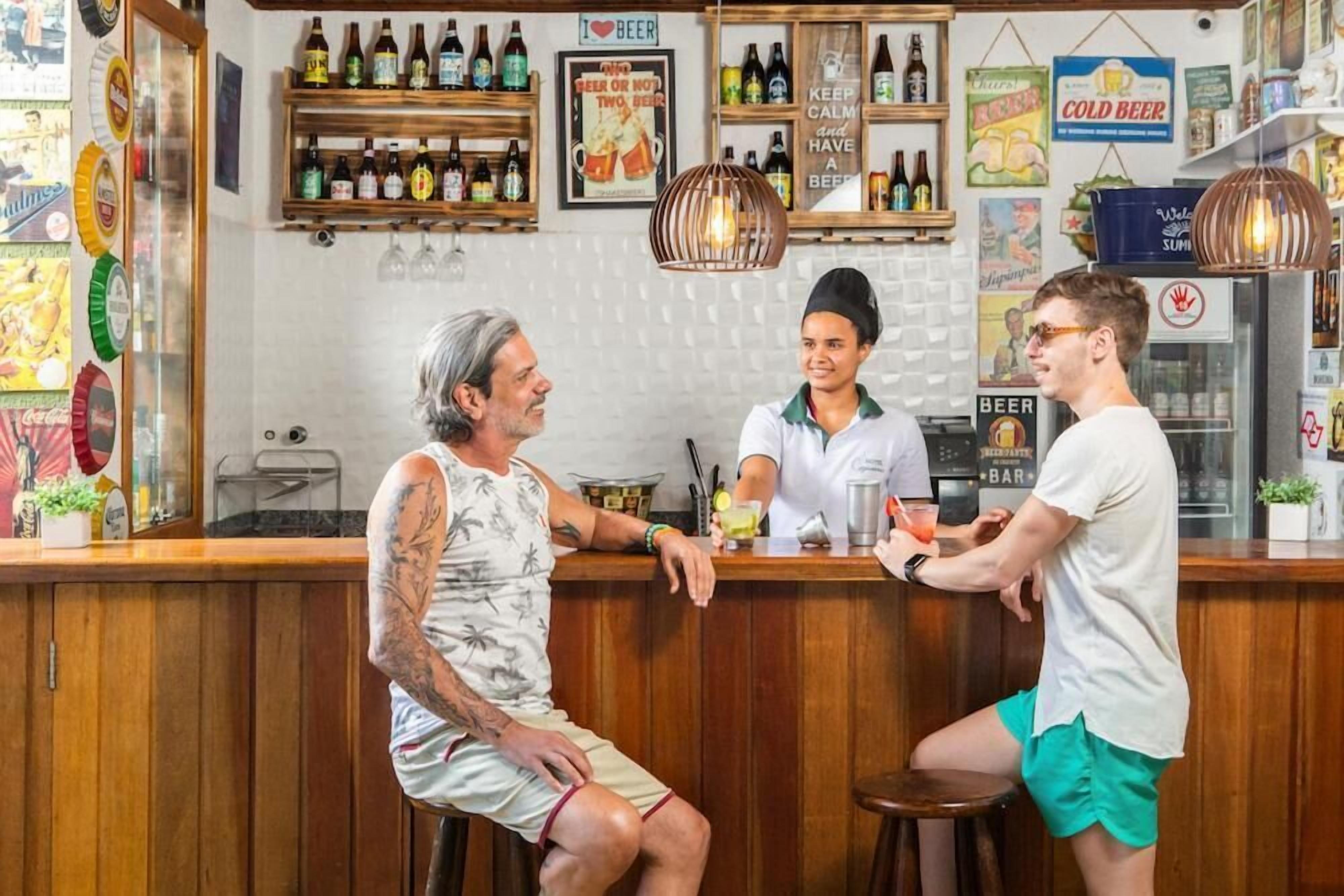Un bar con mostrador de madera y estantes llenos de botellas.