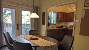 A dining area with a table, chairs, and a hanging light fixture. - Modern Eco-Friendly Townhouse; Walk to Park & Recreation King Bed (Irving)