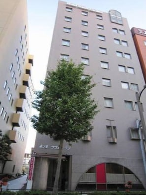 Stunning building with modern design, clean lines, and a natural touch from the tree in front.