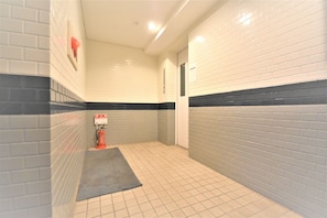Stylish hallway with a black stripe, light-colored tiles, and a door.