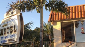 A motel sign with a palm tree in front. - Moonlight Beach Motel (Encinitas)
