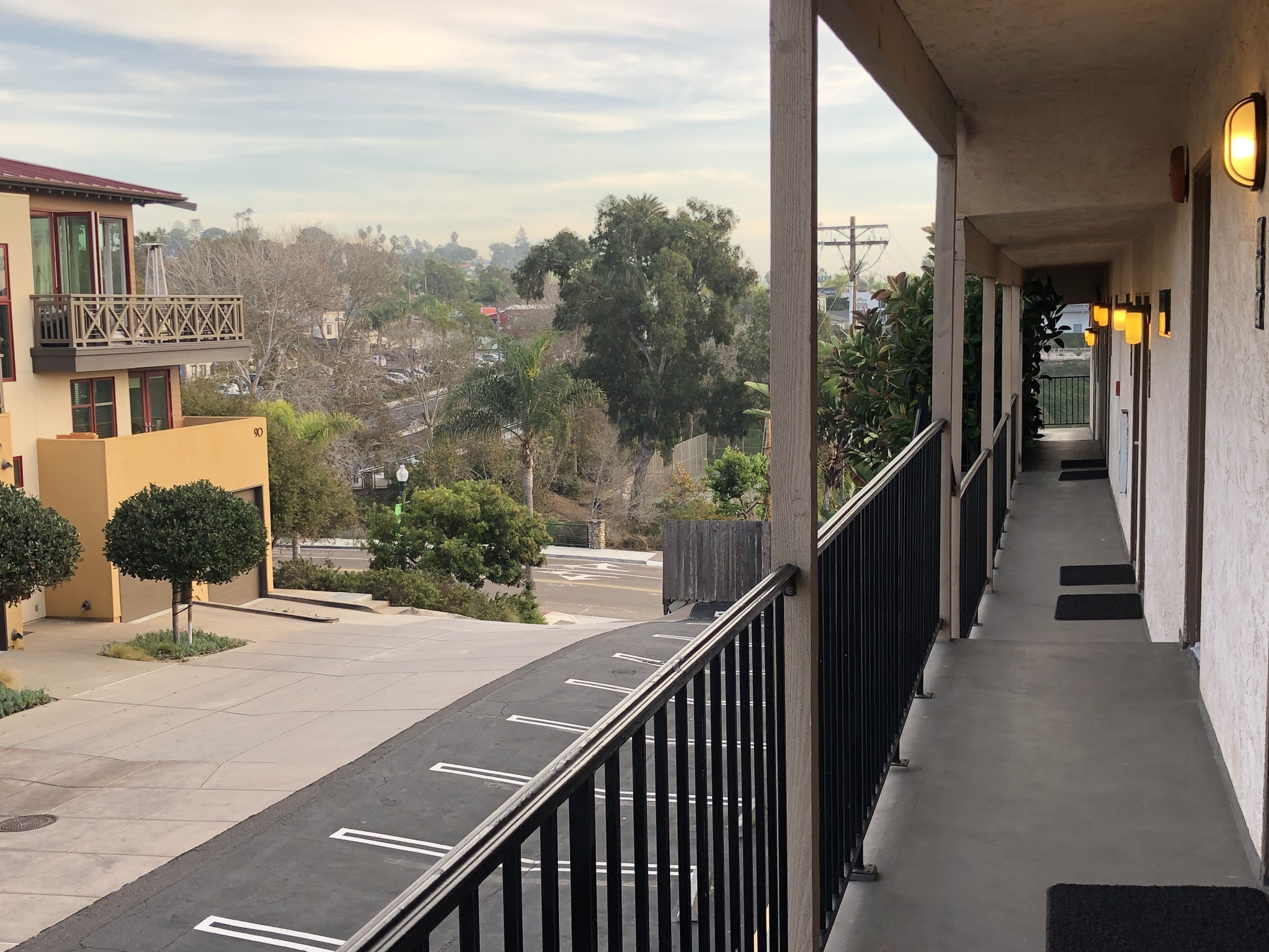 A hotel corridor with a view of the street and surrounding buildings.