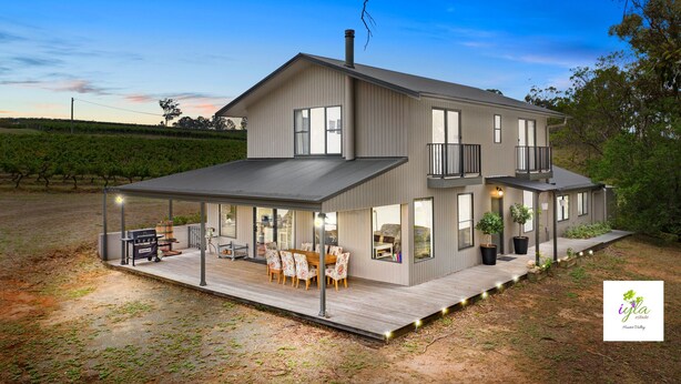 A two-story house with a covered patio, outdoor furniture, and a vineyard in the background. - iyla Estate - Your exclusive Vineyard & Cottage stay @ Pokolbin, Hunter Valley! (Pokolbin)