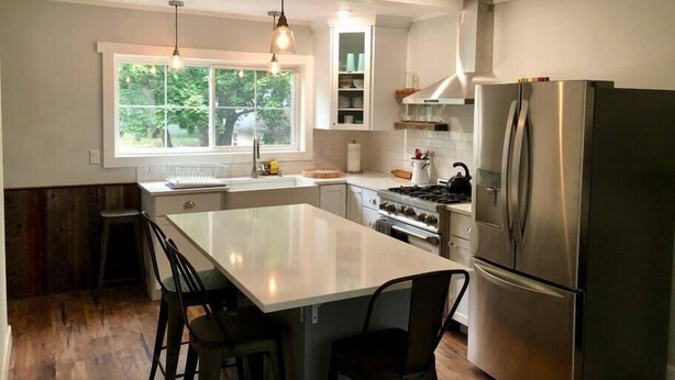 A kitchen with a large island, stainless steel appliances, and pendant lighting. - *Sandpoint Cottage* Cozy, Charming, & Conveniently located (Sandpoint)