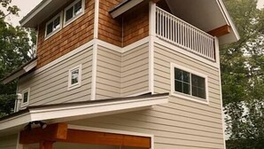 A two-story house with a garage, a covered porch, and a small attached garage. - *Sandpoint Cottage* Cozy, Charming, & Conveniently located (Sandpoint)
