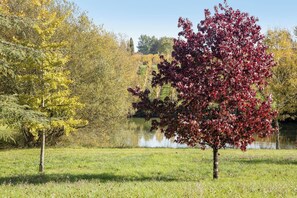 A park with a lake, trees with autumn foliage, and a grassy field. - Homerez - "Sigoulès villa with pool" (Sigoulès)
