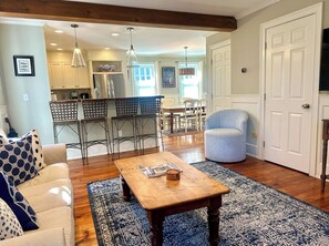 A living room with a sofa, a coffee table, and a patterned rug.