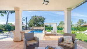 An outdoor patio with wicker furniture, a pool, and a stone wall in the background. - YourHouse Villa Romani con piscina privada y jardín (Muro)