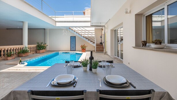 A dining area with a pool, outdoor seating, and potted plants. - Casa moderna con piscina privada y barbacoa, YourHouse Villa Marian (Muro)
