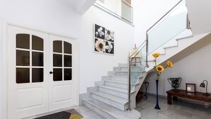 A modern interior with a marble staircase, white doors, and a bench with decorative items. - Casa moderna con piscina privada y barbacoa, YourHouse Villa Marian (Muro)