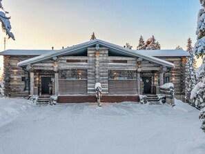 A log cabin with a front porch, a garage, and a driveway. - Villa rytilampi b by Interhome (Kuusamo)