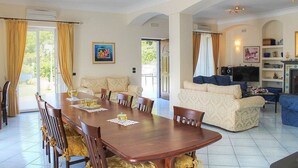 Un espacio habitable amplio con una mesa de comedor, sofás y una televisión.