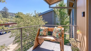 A wooden bench with floral cushions on a balcony with a metal railing. - All About the View - Walk to River, Town, & Trails in Quaint Mosier (Mosier)