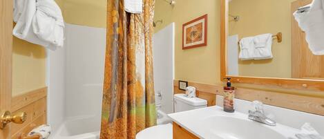 A bathroom with a bathtub, toilet, and sink.