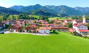 A village with traditional houses, a church, and mountains in the background.