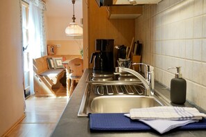 Una cocina moderna con electrodomésticos de acero inoxidable, un fregadero y un comedor con mobiliario de madera.