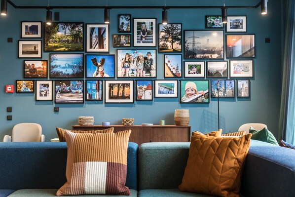 A living room with a blue sofa, a coffee table with decorative items, and a wall adorned with framed photographs.