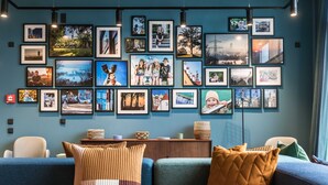 A living room with a blue sofa, a coffee table with decorative items, and a wall adorned with framed photographs.