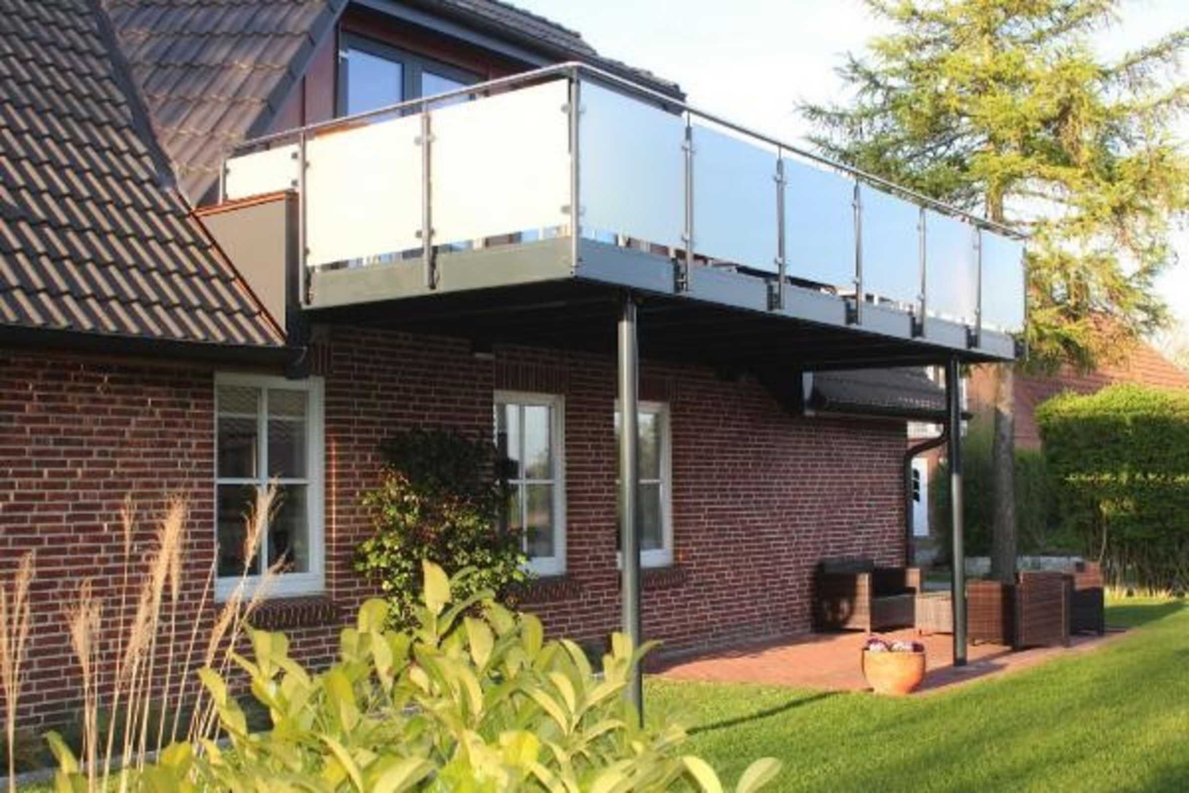 Ein Ziegelhaus mit Balkon und Fenster.