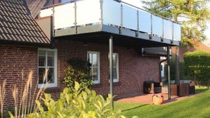 A brick house with a balcony and a window. - Villa an der Au lighthouse - Villa an der Au (Fehmarn)