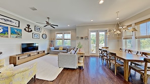 A spacious living room with a TV, sofa, and dining area.