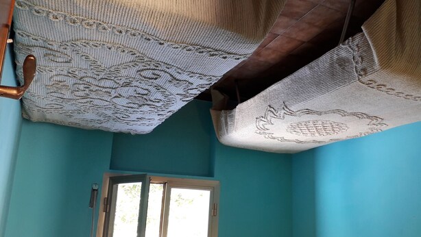A room with teal walls, a window, and a ceiling with patterned fabric. - HOLIDAY HOME LAKE OF SUVIANA (Bargi)
