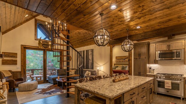 Een ruime keuken met een groot eiland, houten plafond en moderne apparatuur.