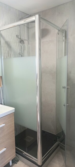 Chuveiro, toalhas de banho, papel higiênico 