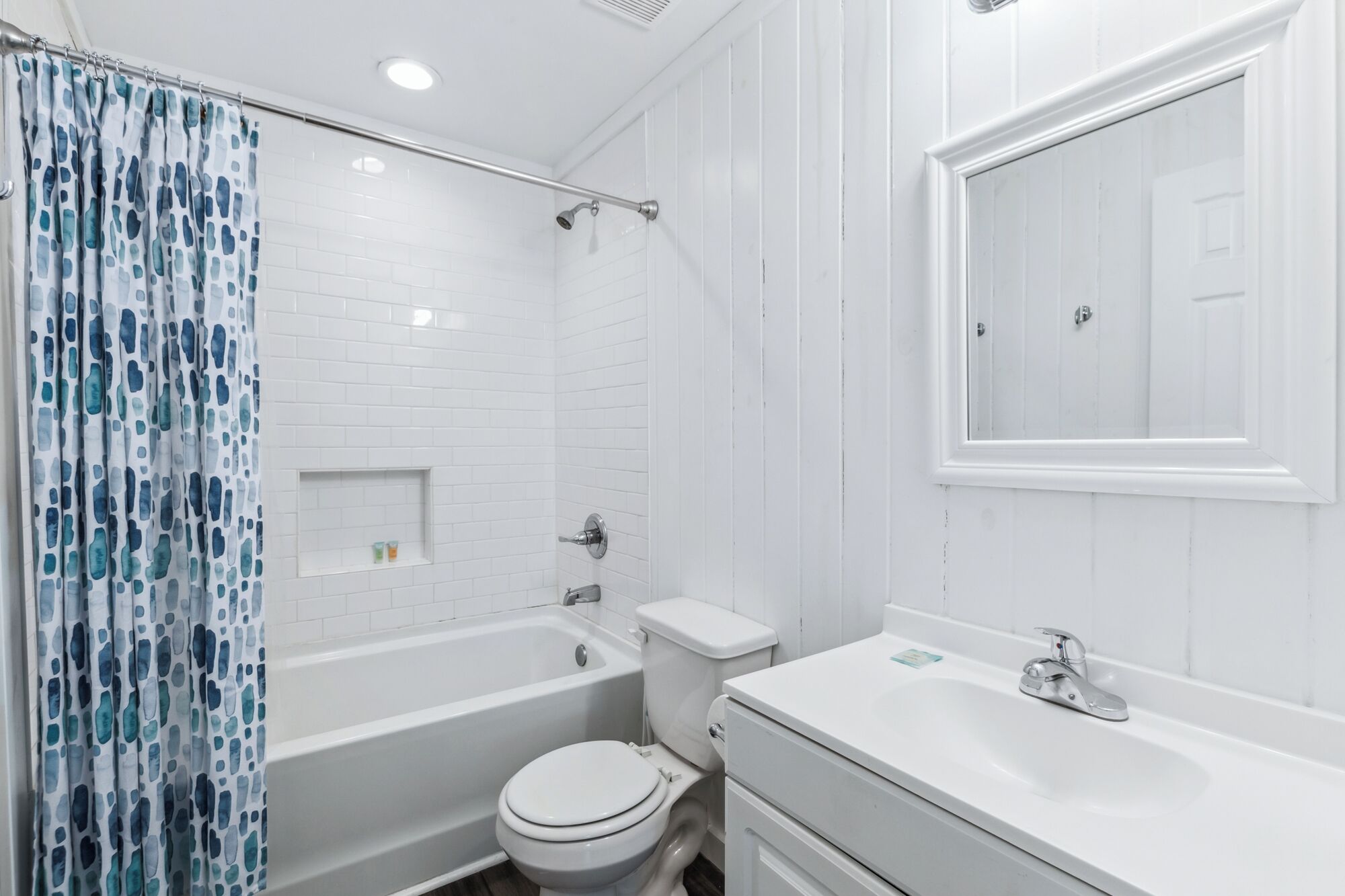 A bathroom with a bathtub, toilet, and sink.