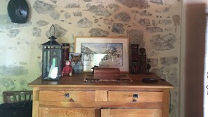 Une commode en bois avec des tiroirs, un tableau encadré, une lanterne et une petite figurine posée sur le dessus.