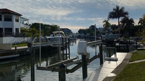 A marina with docked boats, a wooden walkway, and a white building with a balcony. - 3 bedroom, 2 bathroom private pool home just minutes from Siesta Key! (Sarasota)