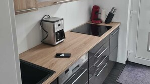 A modern kitchen with a built-in oven, a coffee machine, and a toaster.