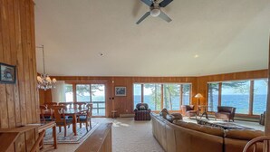Amplia sala de estar con un sofá grande, muebles de madera y vista al océano.