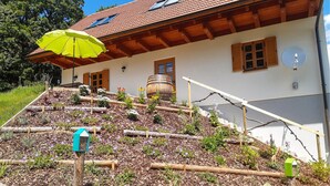Une maison avec un toit en pente, des poutres en bois et un tonneau en bois.