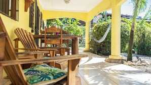 A covered patio area with wooden furniture and a hammock. - Tropical Patio & Garden, Walk to Samara Beach
 (Sámara)