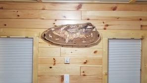 A wooden wall with a decorative map and the text "God's Country" above two closed roller shutters.