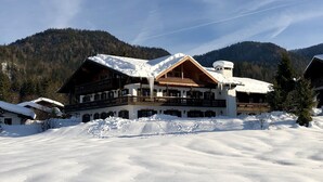 A large lodge with multiple balconies and a snow-covered roof, surrounded by mountains. - Living - vision - well-being ***** with attention to detail! (Reit im Winkl)