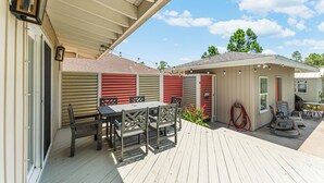 A covered outdoor patio with a table and chairs, a hose, and a small shed. -  Pet Friendly Cape San Blas Getaway Near the Gulf (Cape San blas)