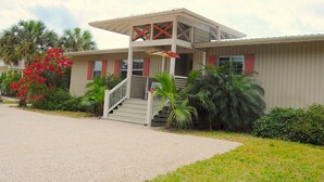 A two-story building with a covered porch and a staircase leading to the entrance.