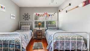 A bedroom with two beds, a ceiling fan, a window with blinds, and a wall clock. -  Pet Friendly Cape San Blas Getaway Near the Gulf (Cape San blas)
