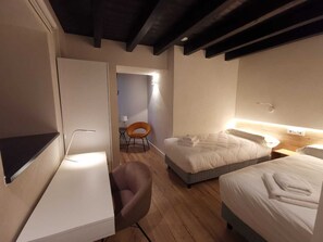 Relax in a stylish room with a neatly made bed, desk, and comfortable armchair.