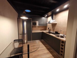 Compact kitchen with modern design, stainless steel appliances, and a sleek sink area.